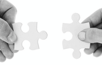 Two hands joining two jigsaw puzzle pieces — couple therapy